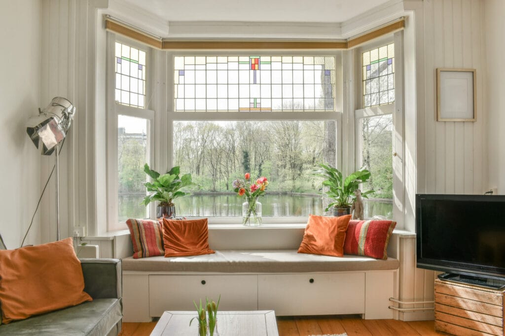 Elegant living space with Keystone Window's bay windows, providing ample natural light and panoramic views of a serene outdoor setting, enhancing the home's aesthetic and comfort.
