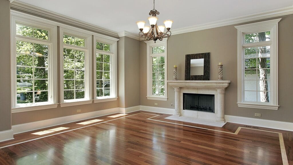 Spacious living room with large energy-efficient windows and polished wooden floor.