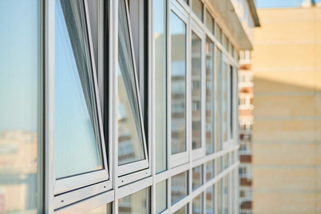Close-up view of a row of open awning windows installed by Keystone Window, allowing for increased airflow and natural light in a modern building facade.